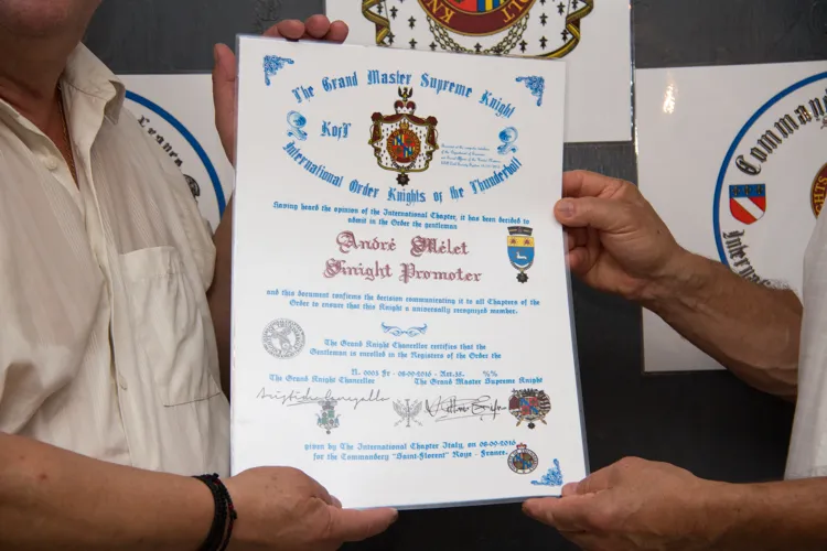 Chevalier André MÉLET tenant son diplôme officiel.